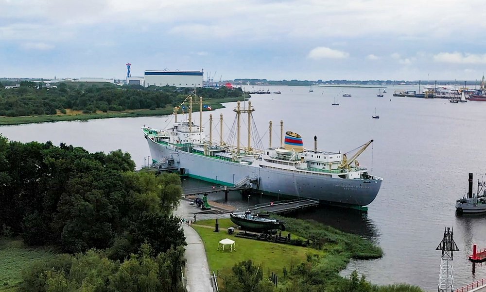 Luftaufnahme von Frachtschiff MS Dresden und Schwimmkran. Im Hintergrund Hafenanlagen von Überseehafen
