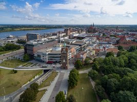 Luftaufnahme des Kröpeliner Tors mit dem Vorplatz. Im Hintergrund die Rostocker Innenstadt mit Fluss Warnow 
