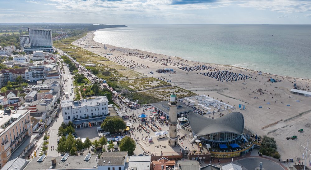 Warnemünder Strand und Promenade zur Hanse Sail. Historischer Leuchtturm im Vordergrund